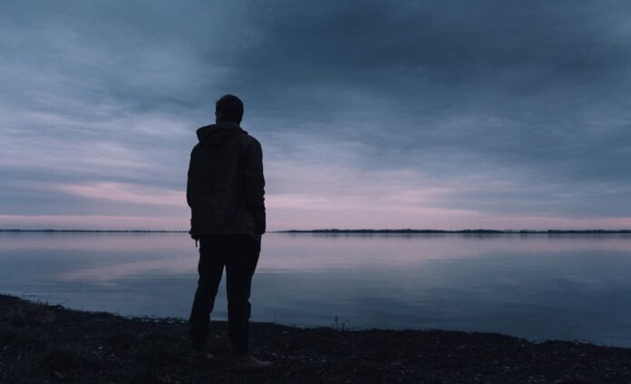 person standing near lake